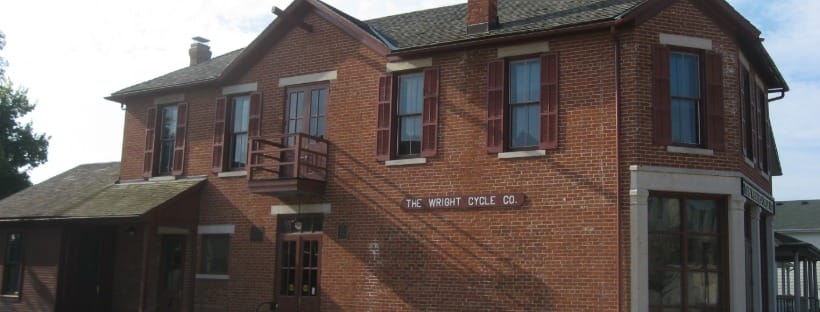 Historic red-brick Wright Cycle Company building in Dayton with original signage and second-story windows.