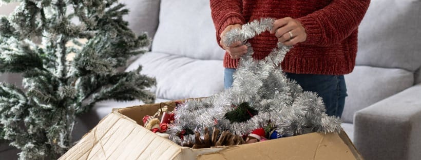 Holiday decorations being packed into a box as part of an organized post-holiday cleanup.